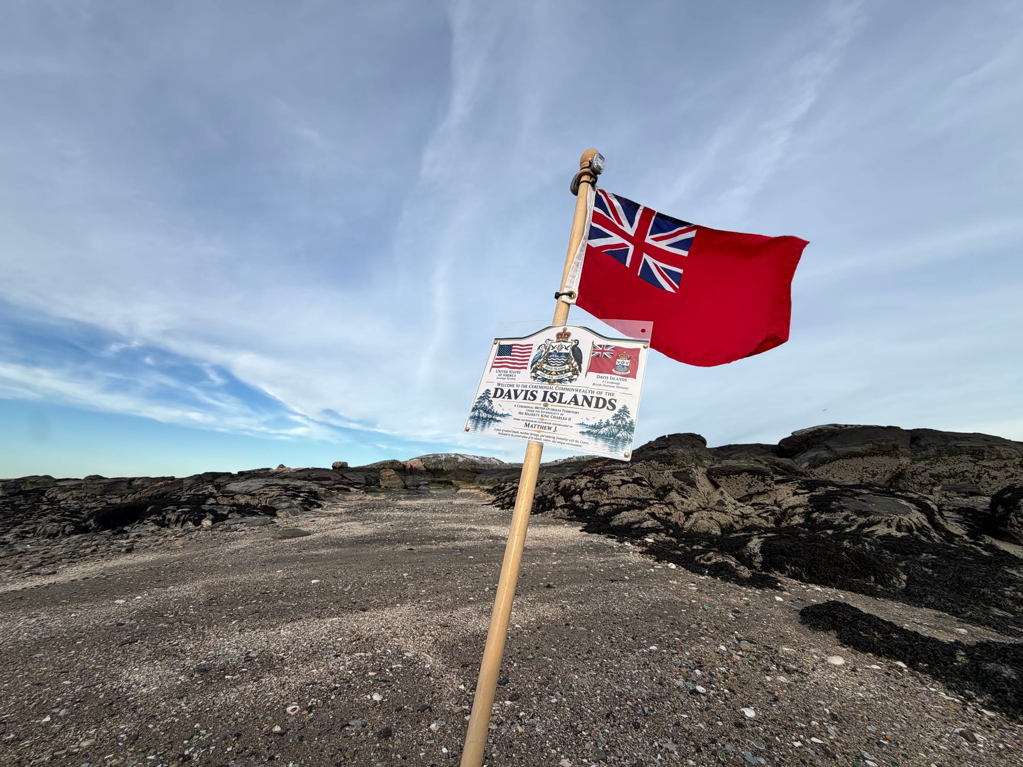 The Davis Islands Red Ensign flying beside a Davis Islands plaque on the rocky island